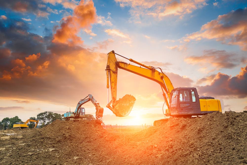 Heavy equipment operators digging with backhoes